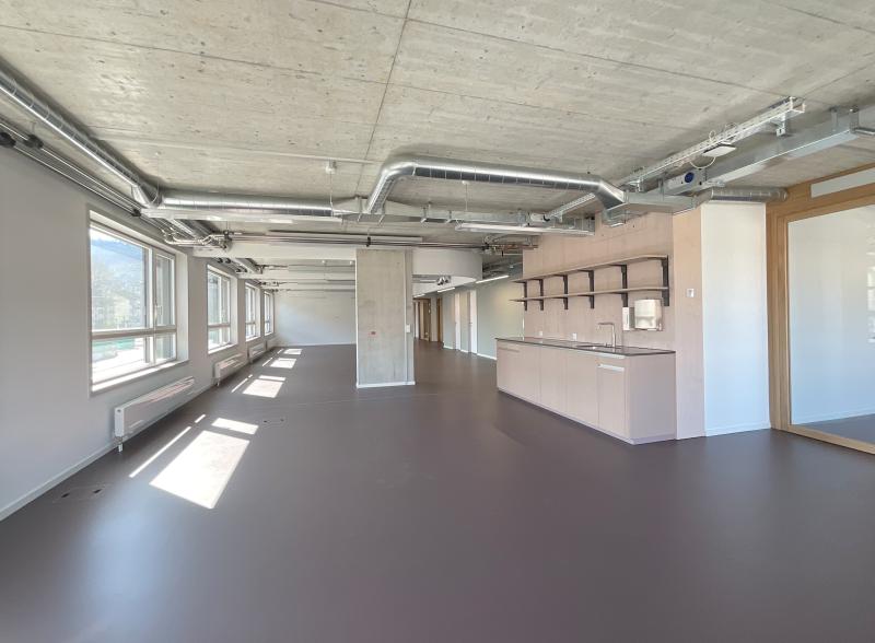 Leeres Bürogeschoss mit Fensterfront, Betondecke und Empfangsbereich im Hochhaus Hoch3 der Genossenschaft ABZ.