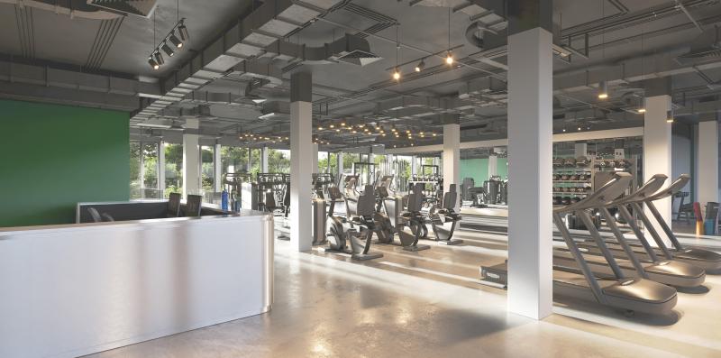 Empfangsbereich mit weißer Theke und Blick auf Fitnessgeräte im Gewerbehaus Bahnhofstrasse Wald.