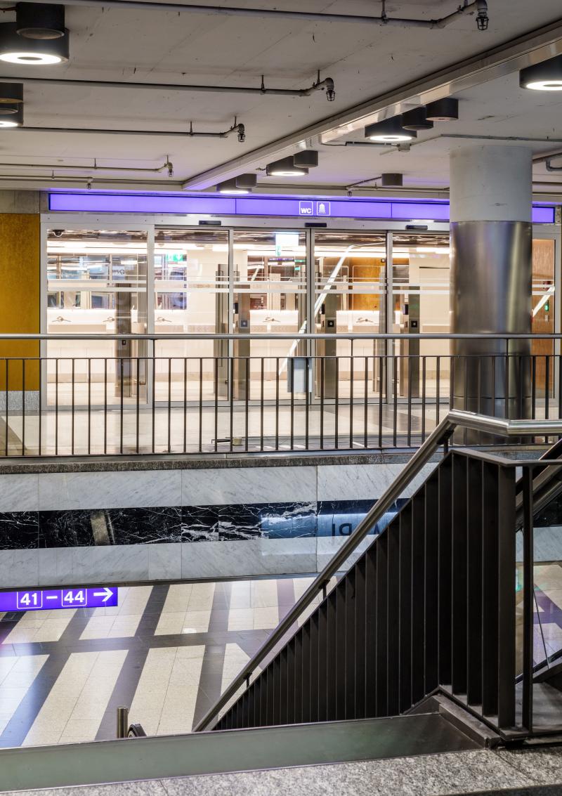 Treppenaufgang mit Blick auf das erneuerte Hygienecenter im Zwischengeschoss des Zürcher Hauptbahnhofs.