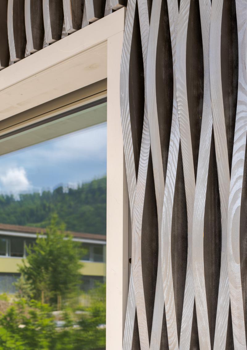 Holzfassade mit vertikalem Flechtmuster am Doppelkindergarten Werd in Adliswil.
