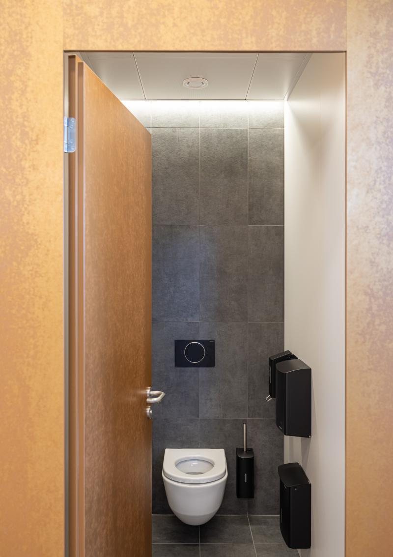 Toilettenbereich mit Wandtoilette und schwarzen Accessoires in den Kundenbereichen der SBB.