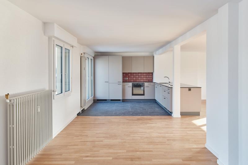 Offene Wohnküche mit Holzboden in einem der Mehrfamilienhäuser aus dem Jahr 1951 in der Luzerner Innenstadt.