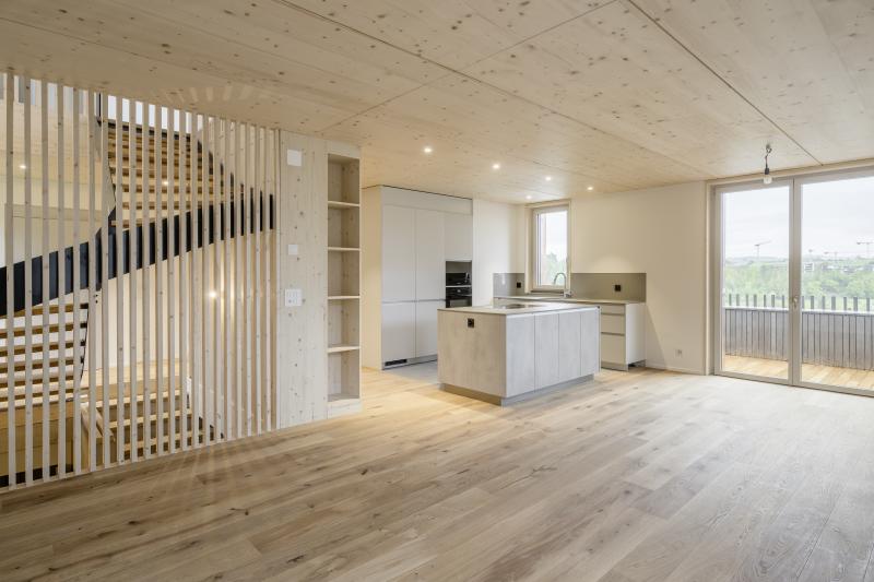 Offene Wohnküche mit Holzoberflächen in einem Mehrfamilienhaus in Adliswil.