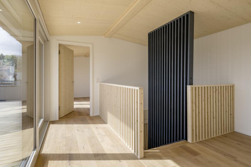 Flur mit Holzverkleidungen in schwarzer und heller Ausführung in einem Mehrfamilienhaus in Adliswil.