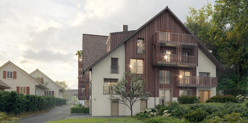 Mehrfamilienhaus Manzelnweg in Tägerig mit asymmetrischer Fassade aus Holz und Putz auf grüner Wiese.
