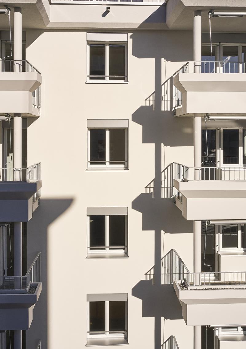 Fassadenausschnitt eines mehrgeschossigen Mehrfamilienhauses an der Rütistrasse in Schlieren nach energetischer Sanierung und Aufstockung.