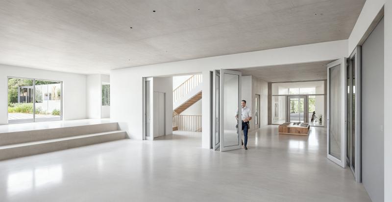 Helle Eingangshalle mit Treppen und großflächigen Verglasungen in der Primarschulanlage Rothenthurm.