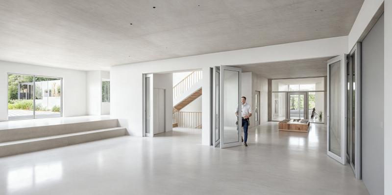 Helle Eingangshalle mit Treppen und großflächigen Verglasungen in der Primarschulanlage Rothenthurm.