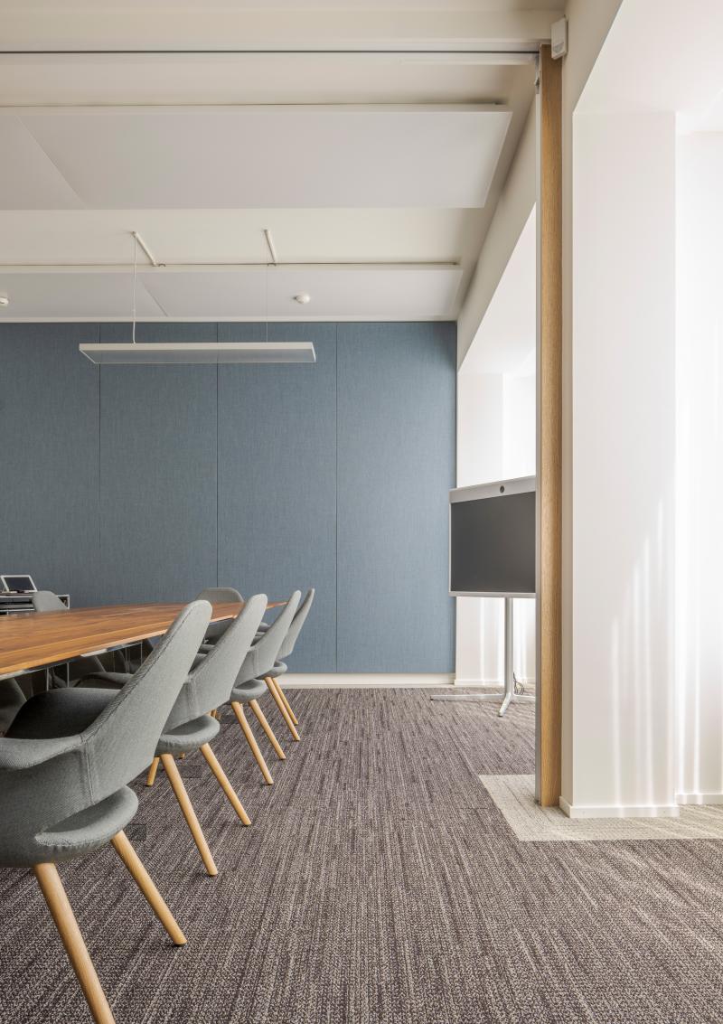 Besprechungsraum mit blauer Wand und Holztisch in der Zürich Branch einer internationalen Privatbank.