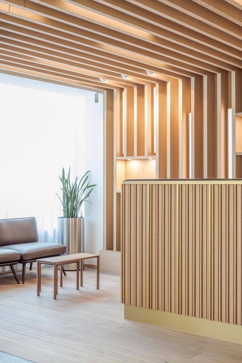 Holzlamellenwand und Empfangsbereich in der Zurich Branch einer internationalen Privatbank.