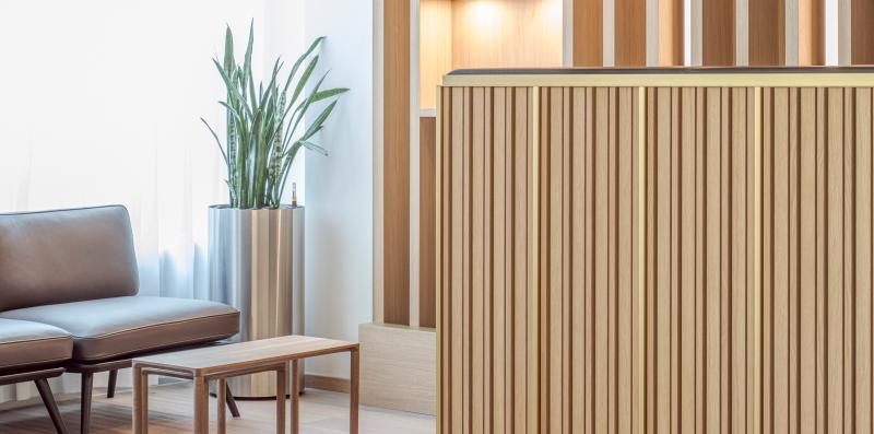 Holzlamellenwand und Empfangsbereich in der Zurich Branch einer internationalen Privatbank.