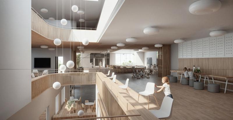 Innenraum der Schulanlage Seefeld mit Empfangsbereich, Sitzgelegenheiten und Hängeleuchten.