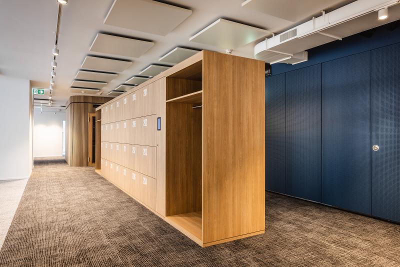Flur mit Holzschränken und dunkelblauen Türen in einem Bürogebäude am Raiffeisenplatz in St. Gallen.