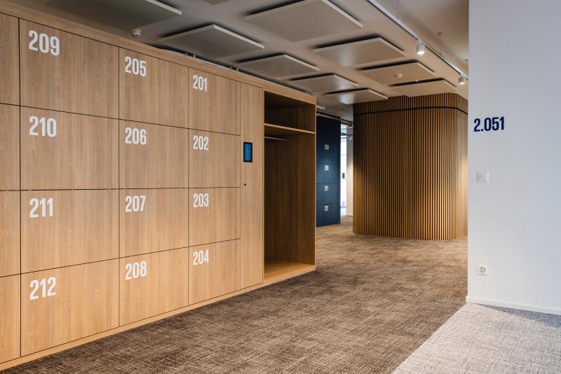 Flur mit nummerierten Holzboxen und Aufzug in einem Bürogebäude am Raiffeisenplatz in St. Gallen.