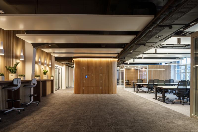 Büroflur mit Holzverkleidung und modernen Arbeitsplätzen für eine Unternehmensberatung in Zürich.