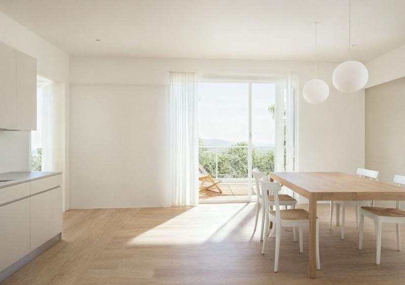 Helles Wohnzimmer mit Holzdielen, Esstisch und Blick auf die Landschaft in der Wohnsiedlung Oetwil am See.